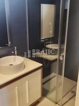 Modern and tidy bathroom with a washbasin and walk-in shower. - image 8