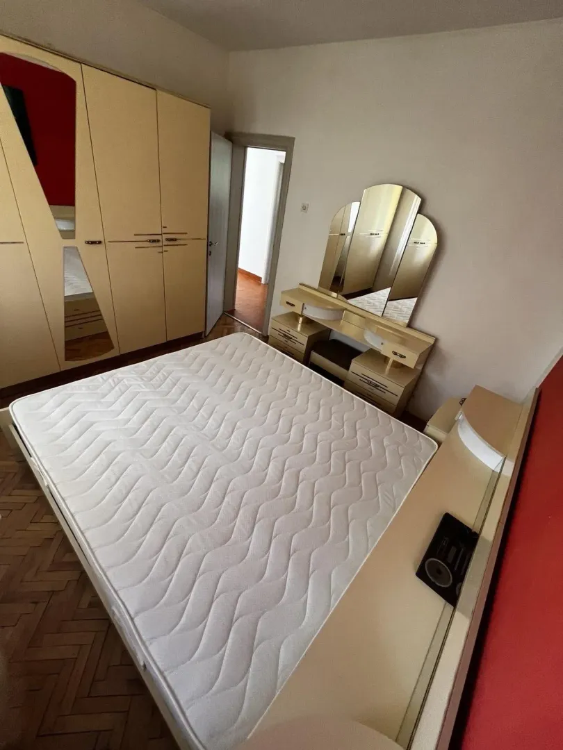 Svijetla spavaća soba sa velikim ormarom i toaletnim stolom.