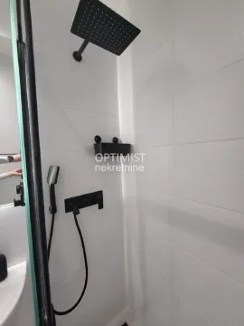 Detalj tuš kabine sa crnim slavinama i belim pločicama. - image 11