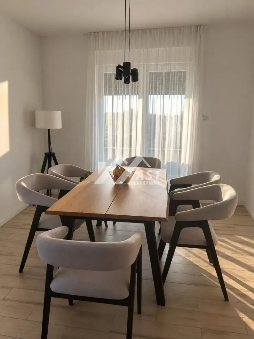 Dining area with a wooden table and modern upholstered chairs.