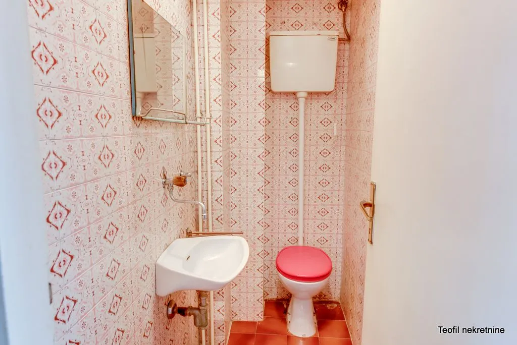 Manje kupatilo sa lavaboom, wc šoljom i retro pločicama.