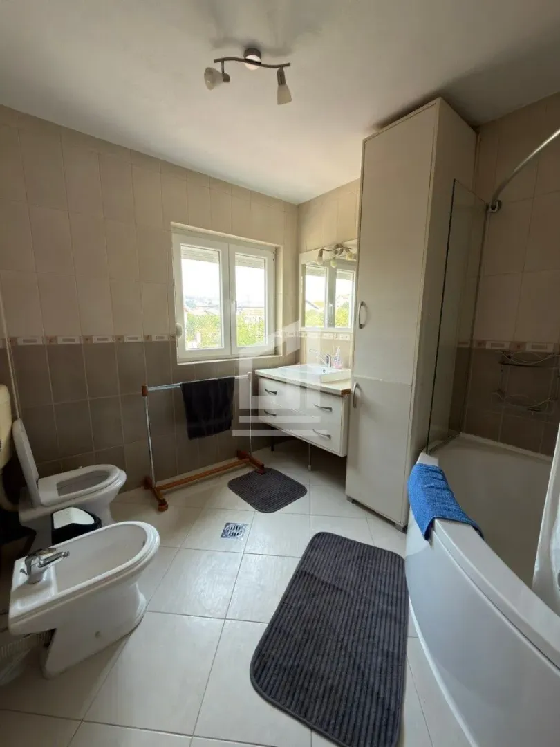 Bathroom equipped with a bathtub, washbasin, toilet, bidet, and a cabinet.