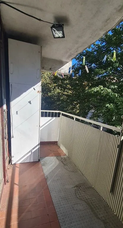Manji balkon sa ormarom i pogledom na zelenilo.