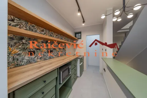 Modern kitchen with green cabinets and wooden shelves. - image 5