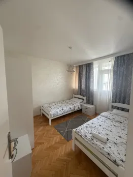 Bright bedroom with two single beds and parquet flooring. - image 5