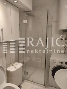 Modern equipped bathroom with a shower cabin and a washing machine. - image 9