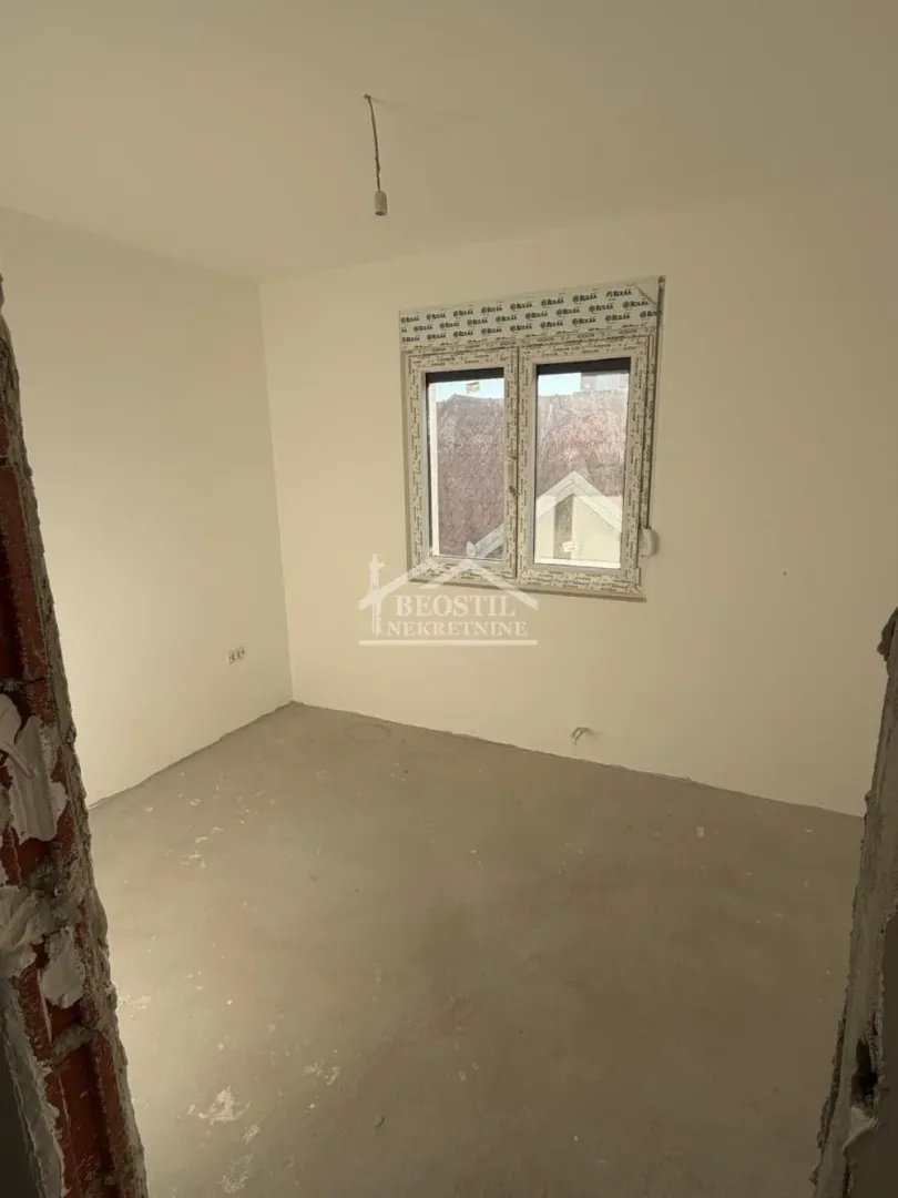 Prazna prostorija u izgradnji sa belim zidovima i ugrađenom PVC stolarijom.