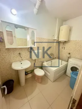 Smaller bathroom with a washbasin, toilet, bathtub, and washing machine. - image 6