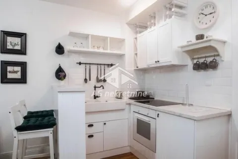Small white kitchen with built-in appliances and a dining bar. - image 11