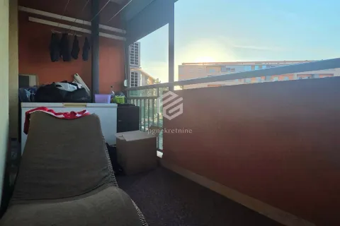 Natkriveni balkon sa namještajem i pogledom na okolne zgrade. - image 10