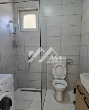 Bathroom equipped with a walk-in shower, toilet, washbasin, and washing machine. - image 7