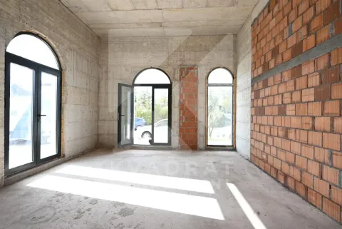 Unfinished room under construction with concrete and brick walls and window openings. - image 5