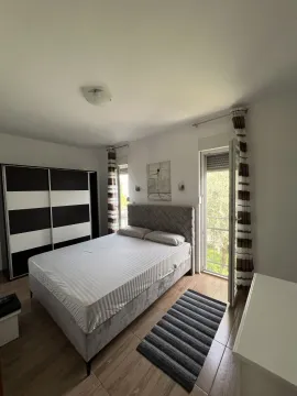Svijetla spavaća soba sa bračnim krevetom, garderoberom i izlazom na balkon. - image 2