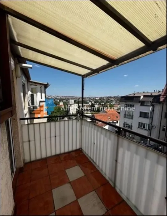 Covered balcony with a view of the city neighborhood.