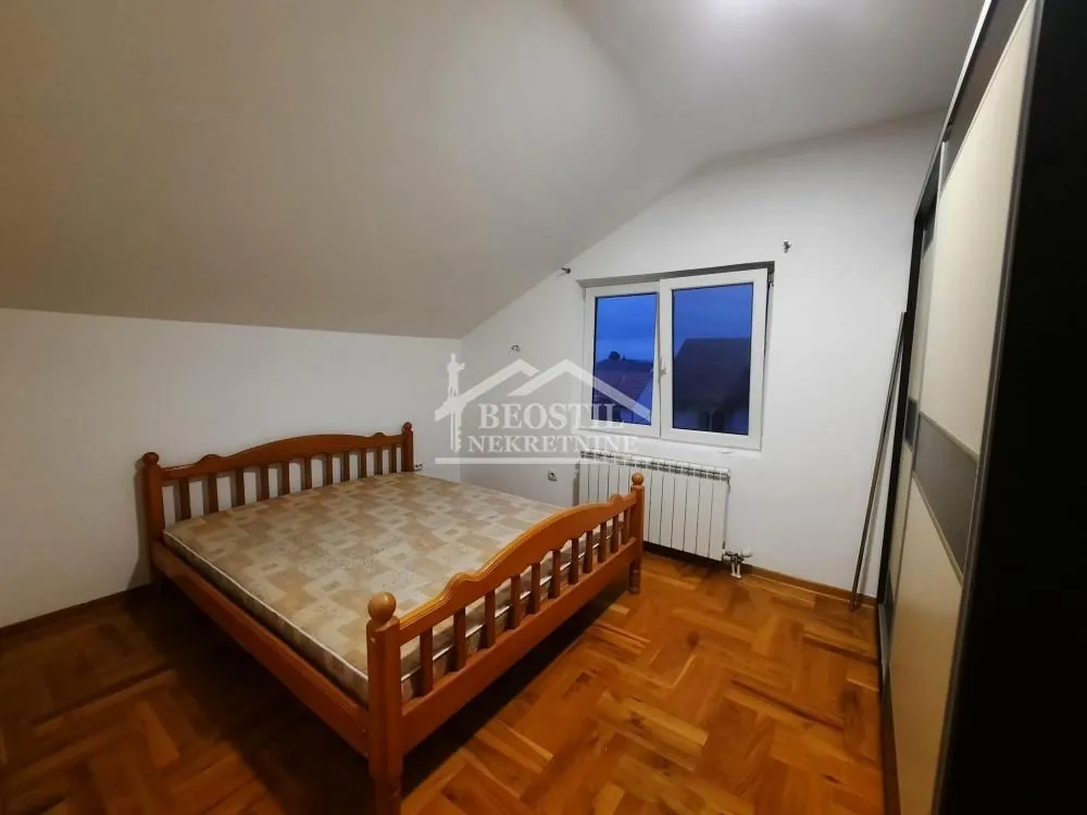 Bedroom with a double bed, wooden floor and a window.