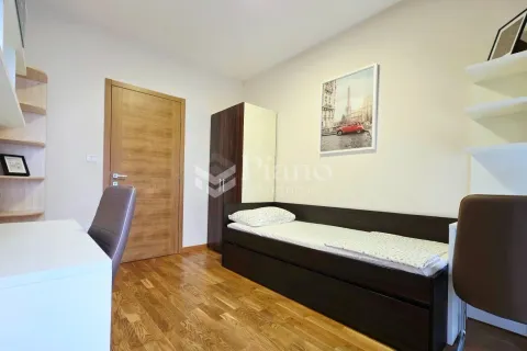 Small bedroom with a bed, wardrobe, desk, and parquet flooring. - image 8