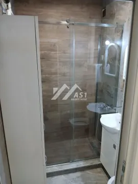 Bathroom with a shower cabin and a washbasin. - image 9