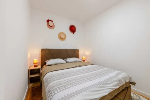 A bedroom with a double bed, nightstands, and decorative hats on the wall. - image 24