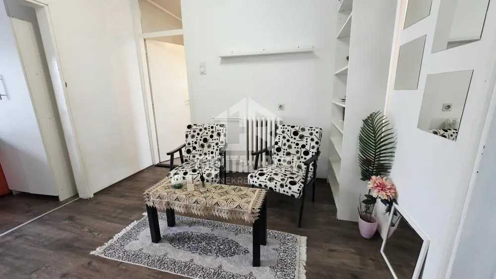 Living room with armchairs, a coffee table, and a bookshelf.