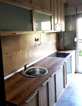 Modern kitchen with wooden units and a sink. - image 4