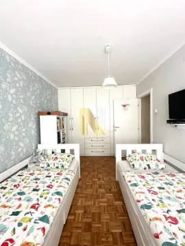 Dečja spavaća soba sa dva kreveta i belim ormanom. - image 8