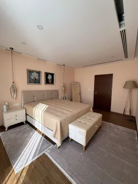 Spacious bedroom with a double bed, bedside tables, and decorative lighting. - image 11