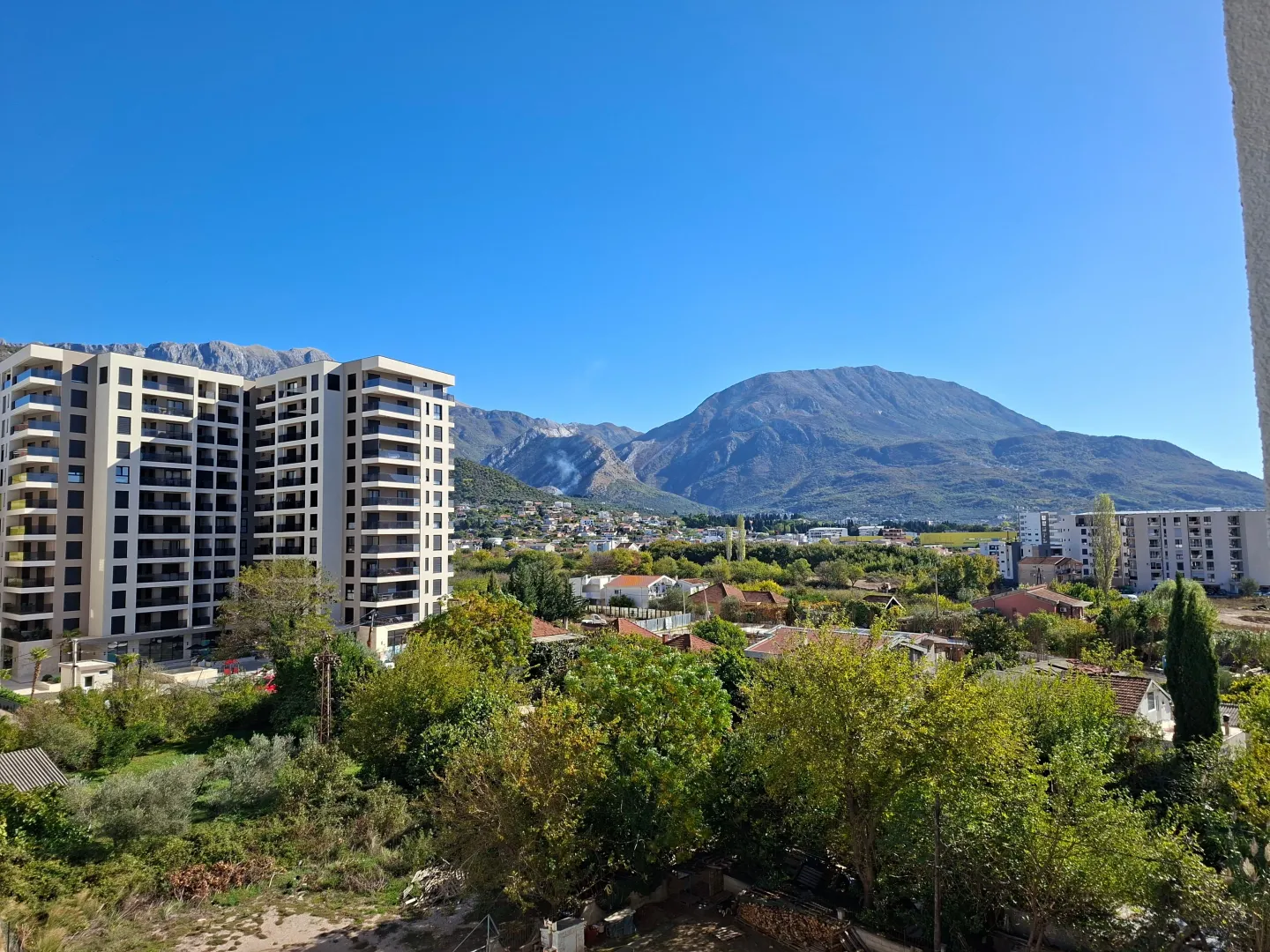 View from the terrace overlooking the neighborhood, surrounding greenery, and mountains.