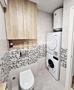 Small bathroom with built-in cabinet, toilet, and washing machine. - image 6