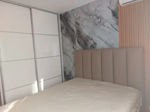 Bedroom with a double bed, large wardrobe, and a decorative wall. - image 15