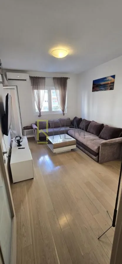 Dnevna soba sa garniturom, stočićem i TV komodom.