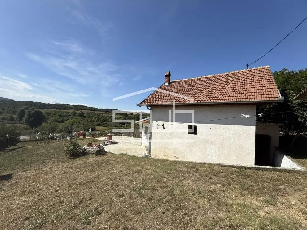 Pogled na spoljašnjost kuće sa dvorištem i prirodnim okruženjem.