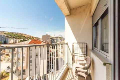 Small covered balcony with metal railing and view of the neighborhood. - image 10