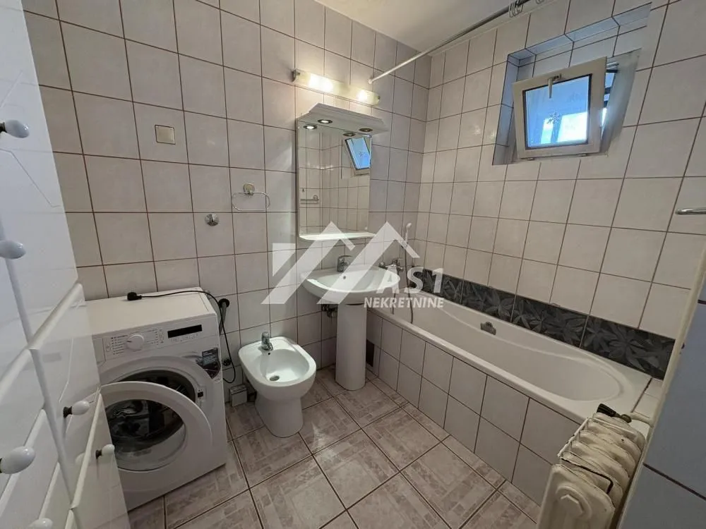Bathroom equipped with a bathtub, washbasin, bidet, and washing machine.