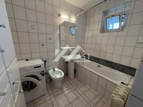 Bathroom equipped with a bathtub, washbasin, bidet, and washing machine. - image 5
