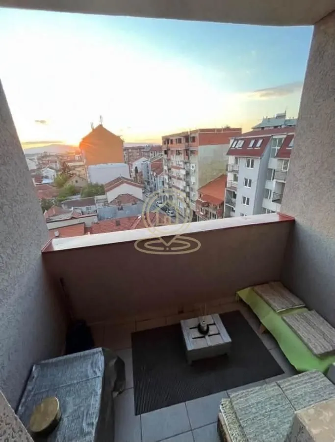Namešten balkon sa garniturom za sedenje i pogledom na grad.