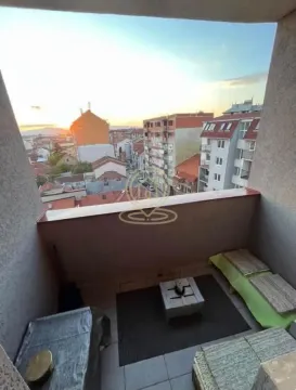 Namešten balkon sa garniturom za sedenje i pogledom na grad. - image 13