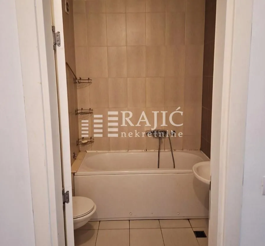 Smaller bathroom with a bathtub, sink, and toilet.