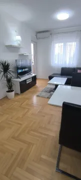 Bright living room featuring parquet flooring, a TV stand, and leather seating. - image 22