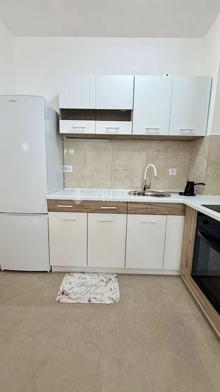 Small bright kitchen with white and wooden elements.
