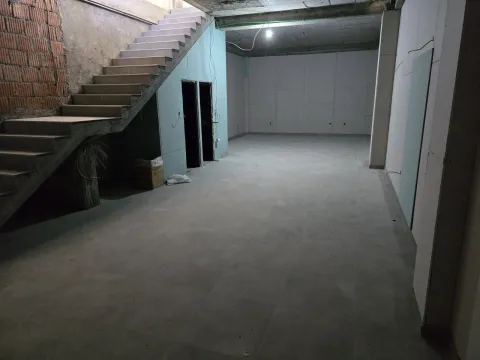 A spacious room in the gray phase of construction with an internal staircase. - image 6