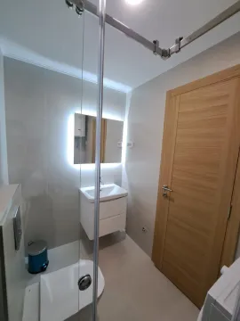 Moderno opremljeno kupatilo sa umivaonikom, ogledalom i tuš kabinom. - image 9