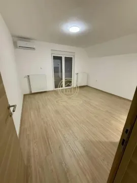 Prazna soba sa laminatom, belim zidovima i balkonskim vratima. - image 3