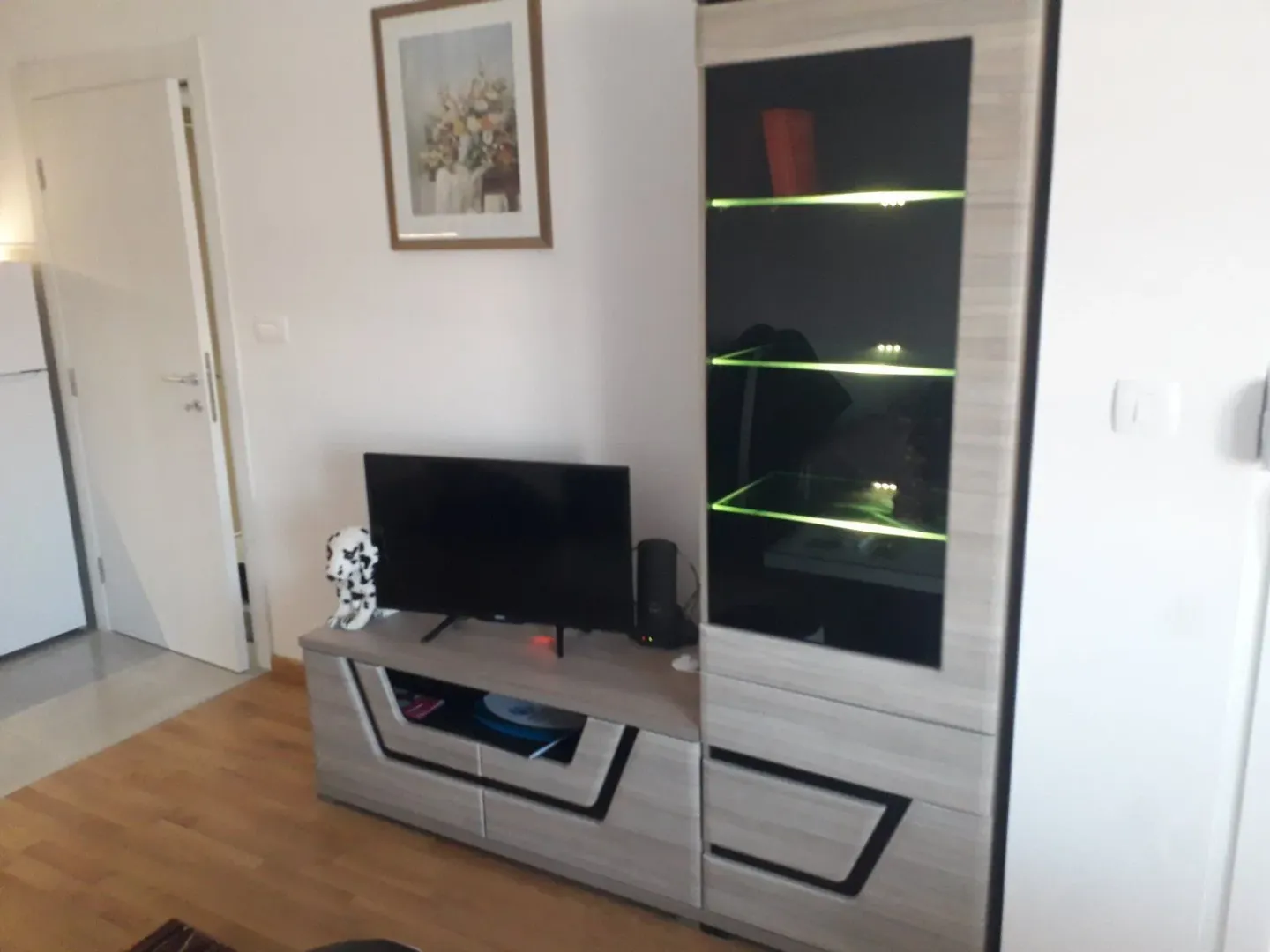 Dio dnevne sobe sa TV komodom i modernom vitrinom.