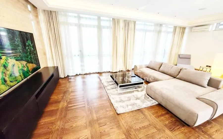 Spacious living room with a large sofa and TV.