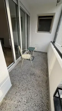 Small narrow balcony with seating furniture and glass sliding doors. - image 8