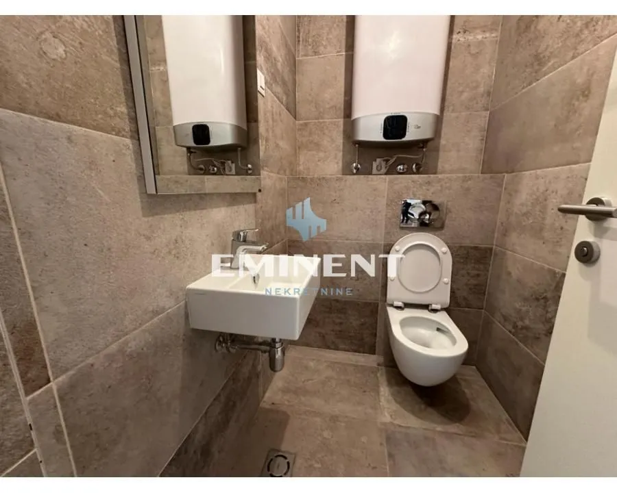 Small tiled bathroom with a sink and a toilet.