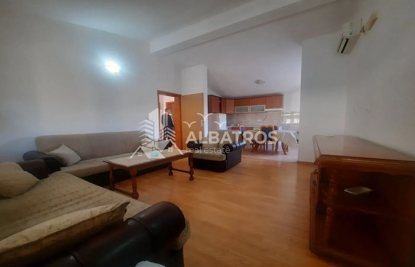 Living room with a sofa set and a view towards the dining area and kitchen.