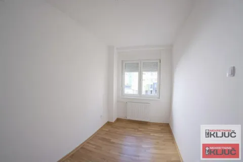 Prazna svetla prostorija sa parketom i jednim prozorom. - image 6