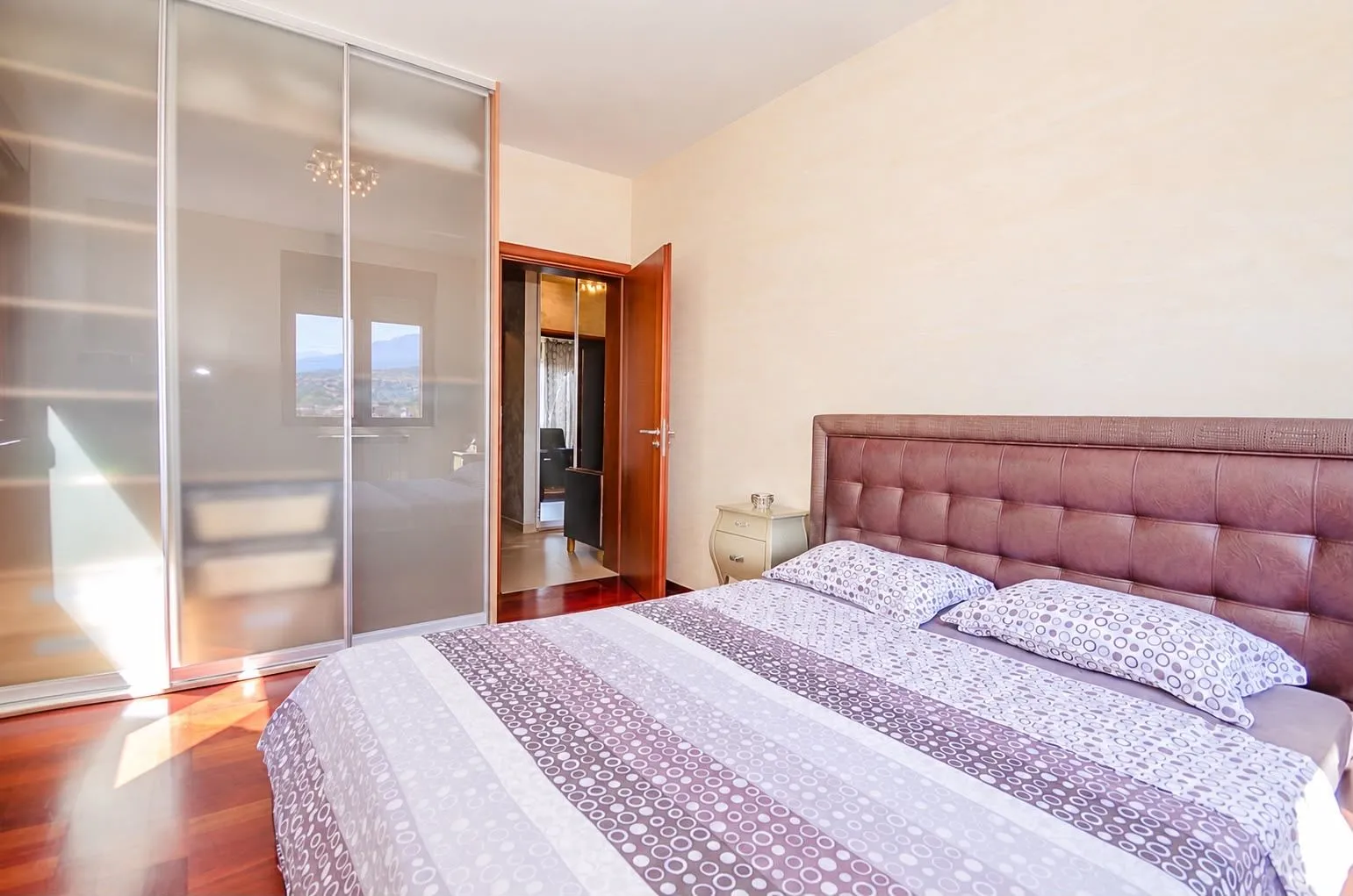Bedroom with a double bed, large wardrobe, and open door leading to the hallway.