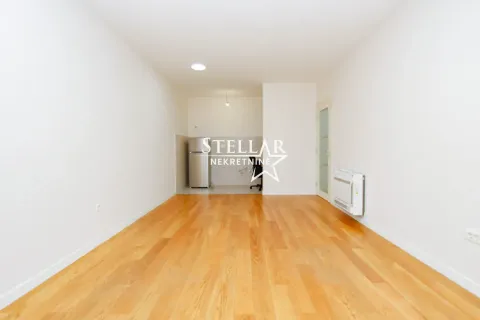 Empty living room with wooden flooring and white walls. - image 2